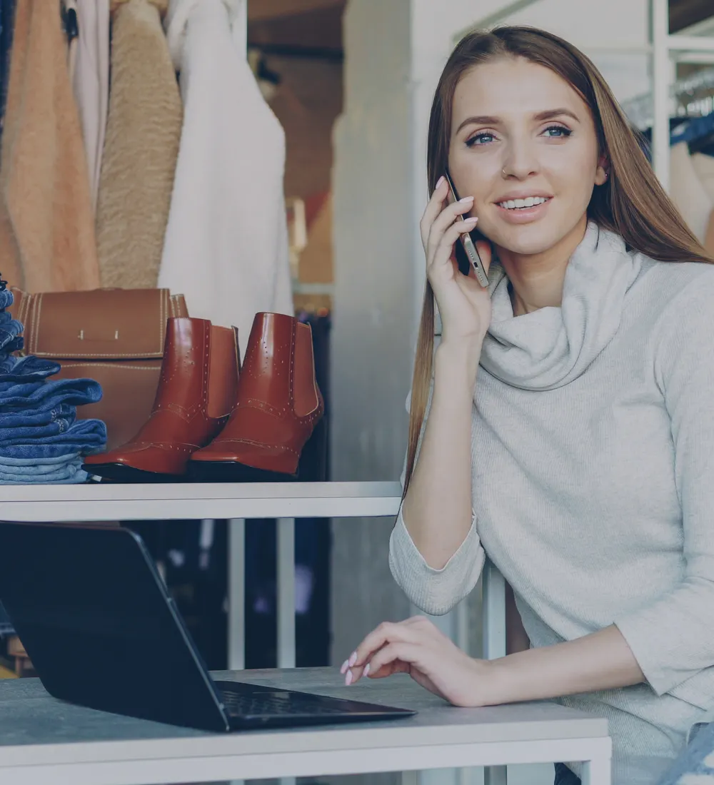 Lojista de moda atendendo cliente ao telefone